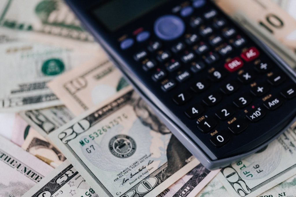 calculator and dollar bills