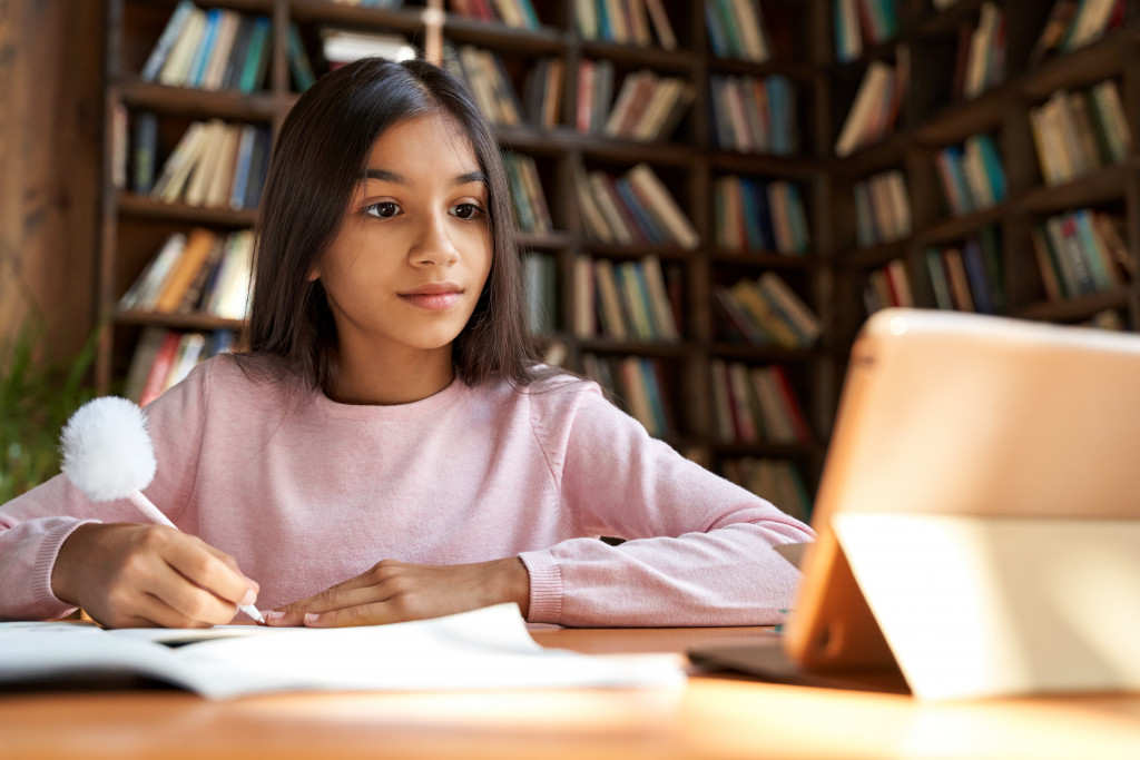 A girl studying at home using her tablet