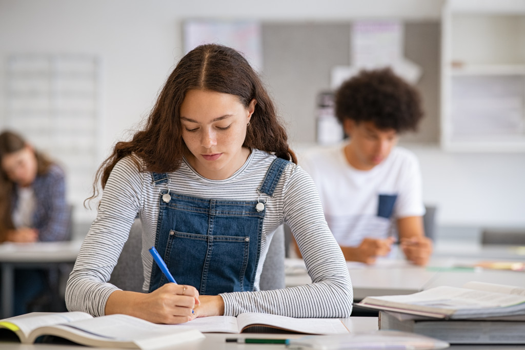 A teen girl studying in school