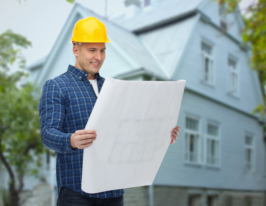 man with hard hat and house at the background