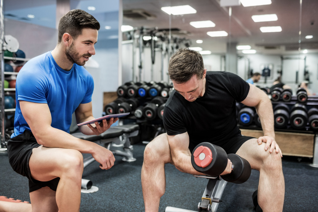 trainer assisting athlete in gym