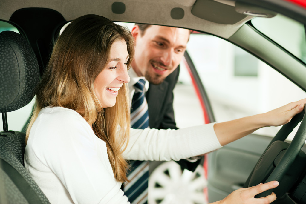 woman wearing white driving a car